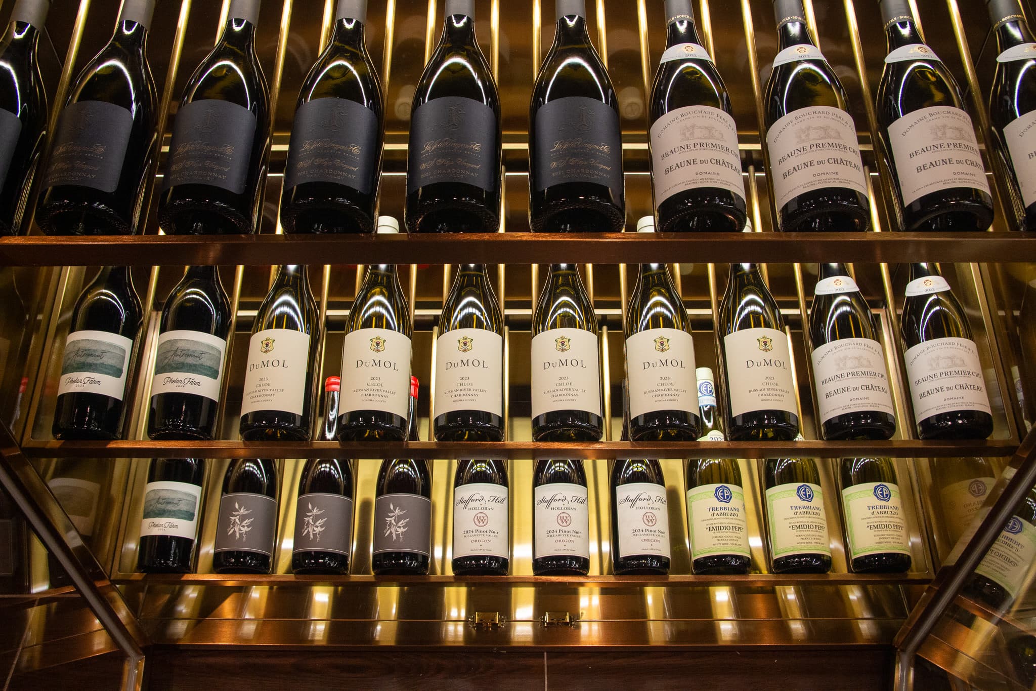 Bottles arranged across The Vault illuminated wine wall